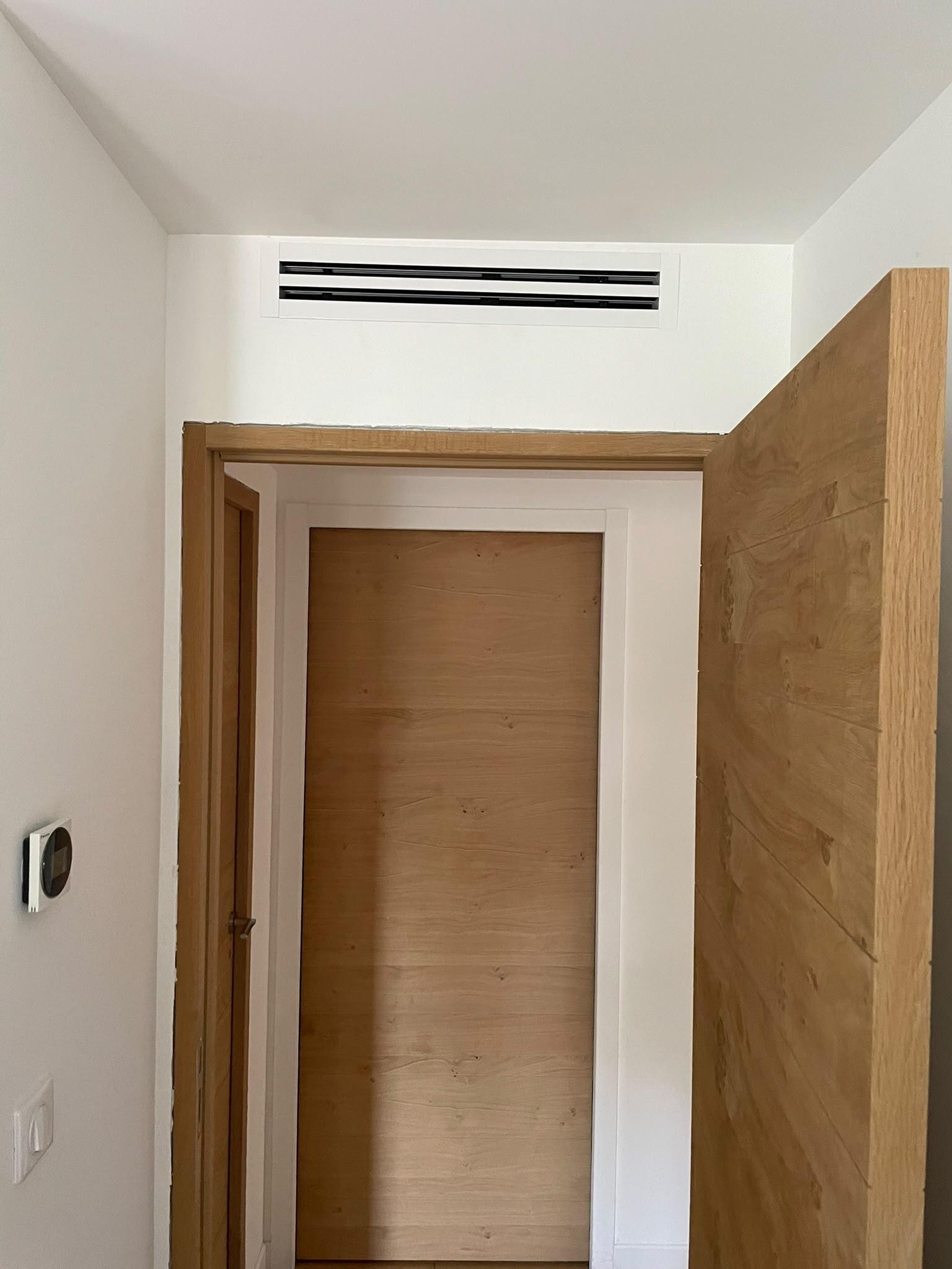 Bouche linéaire de climatisation gainable au-dessus d’une porte